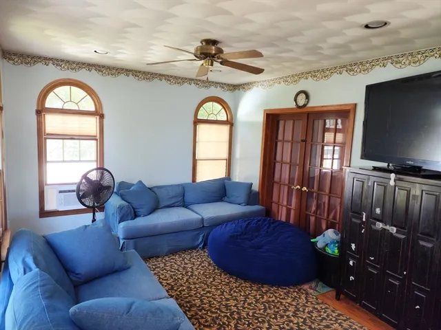 a living room with furniture a flat screen tv and a window