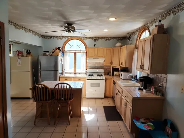 a kitchen with a refrigerator a sink dishwasher a stove and a refrigerator with wooden floor