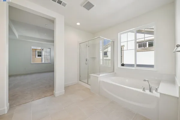 a spacious bathroom with a double vanity sink a mirror and a shower