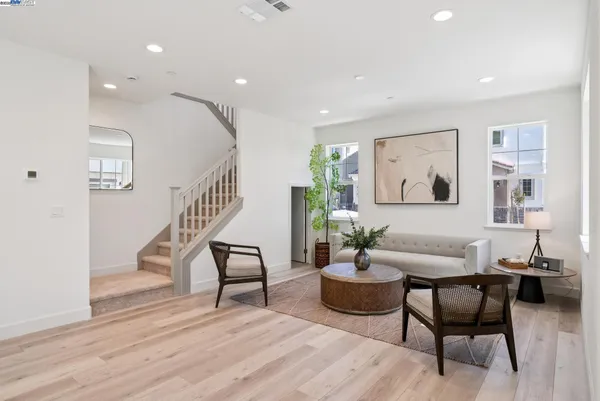 a living room with furniture and a wooden floor