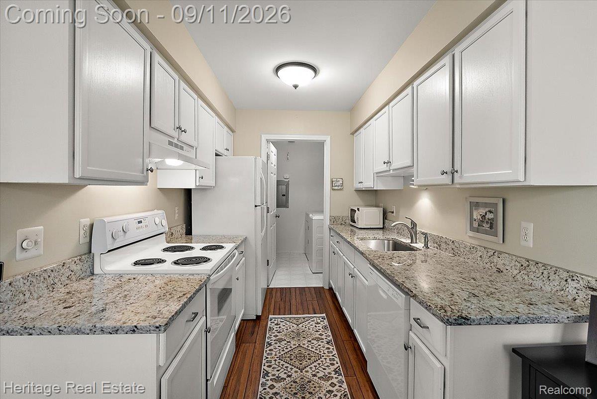 3088 High Pointe Ridge Road Lake Orion, MI 48359 - Photo 10 of 31 Galley kitchen featuring shaker-style cabinetry, undermount sink, granite countertops, and wood-finish flooring