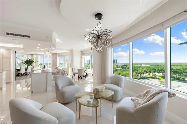 a living room with furniture chandelier and a potted plant