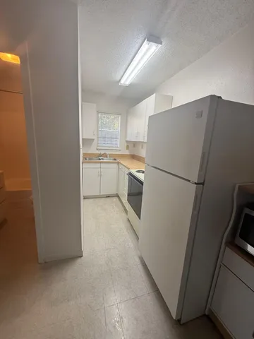 a kitchen with a refrigerator sink stove and cabinets