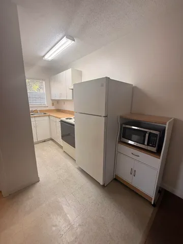 a kitchen with a refrigerator sink and stove top oven