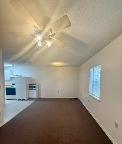 a view of a livingroom with a ceiling fan and window