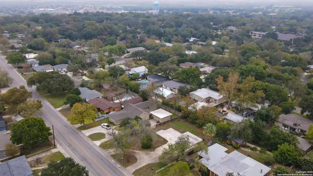 an aerial view of residential houses with outdoor space and trees