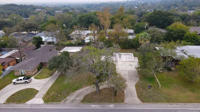 an aerial view of a house with a garden and tree