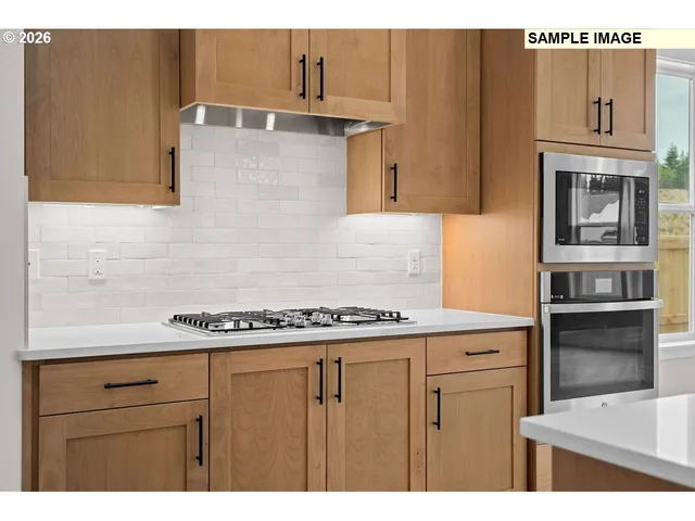 a kitchen with kitchen island granite countertop a sink cabinets and stainless steel appliances