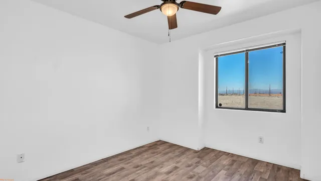 an empty room with fan and windows