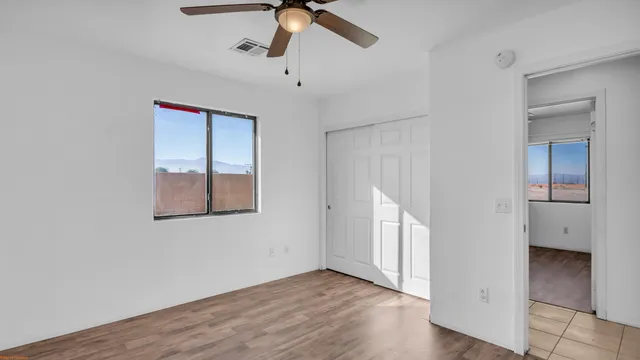 an empty room with a window and wooden floor
