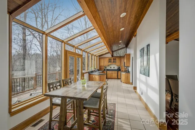 a living room with furniture large windows and wooden floor