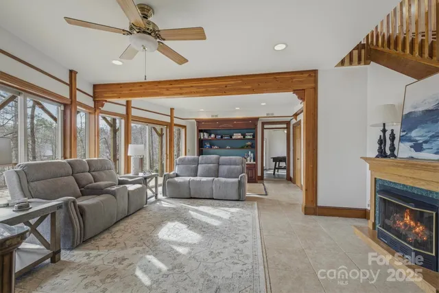a living room with furniture a flat screen tv and a floor to ceiling window