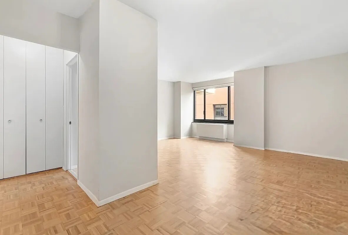 200 Rector Place, Unit 9R Manhattan, NY 10280 - Photo 3 of 12 a view of an empty room with window and wooden floor