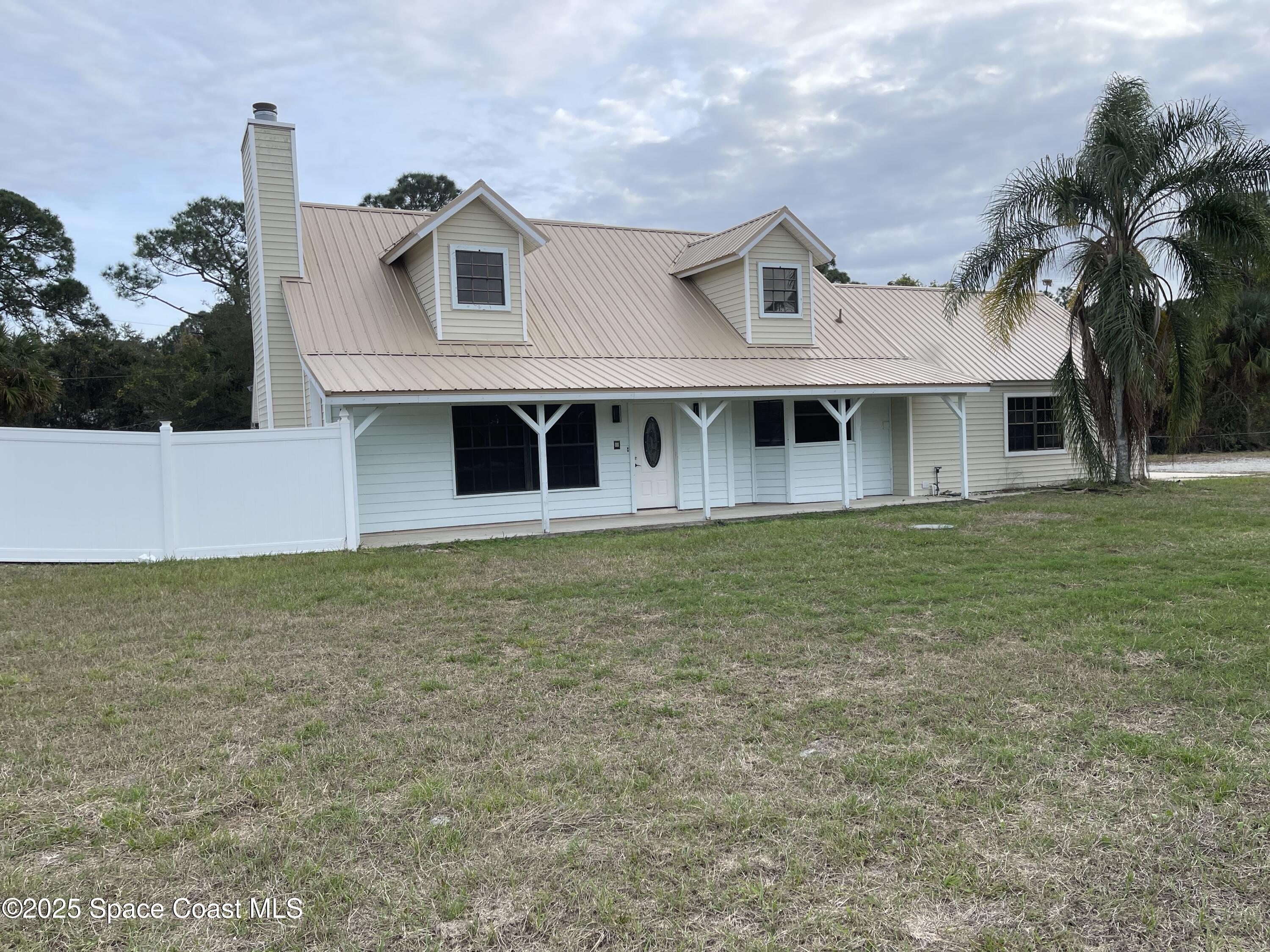 3445 Fox Lake Road Titusville, FL 32780 - Photo 1 of 43 a front view of a house with a garden