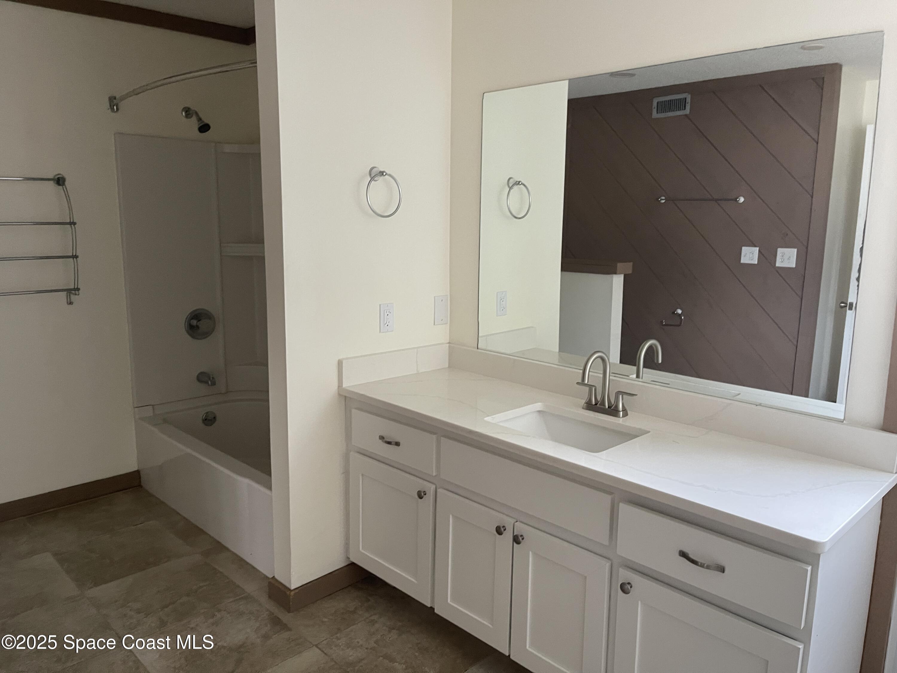 3445 Fox Lake Road Titusville, FL 32780 - Photo 14 of 43 a spacious bathroom with a granite countertop sink a mirror and a bathtub