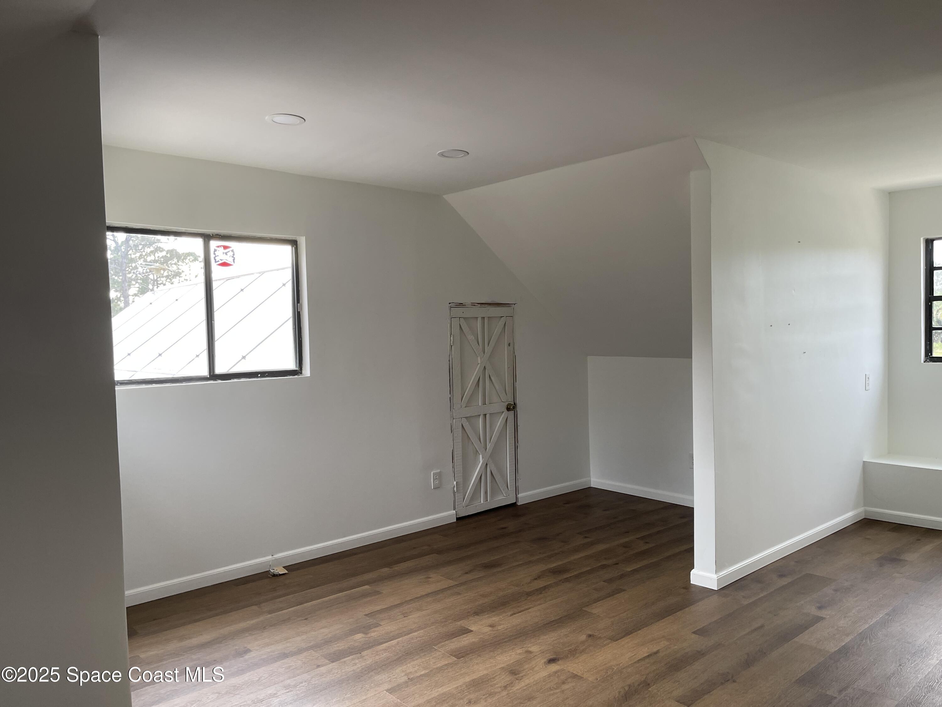 3445 Fox Lake Road Titusville, FL 32780 - Photo 18 of 43 an empty room with wooden floor cabinet and windows