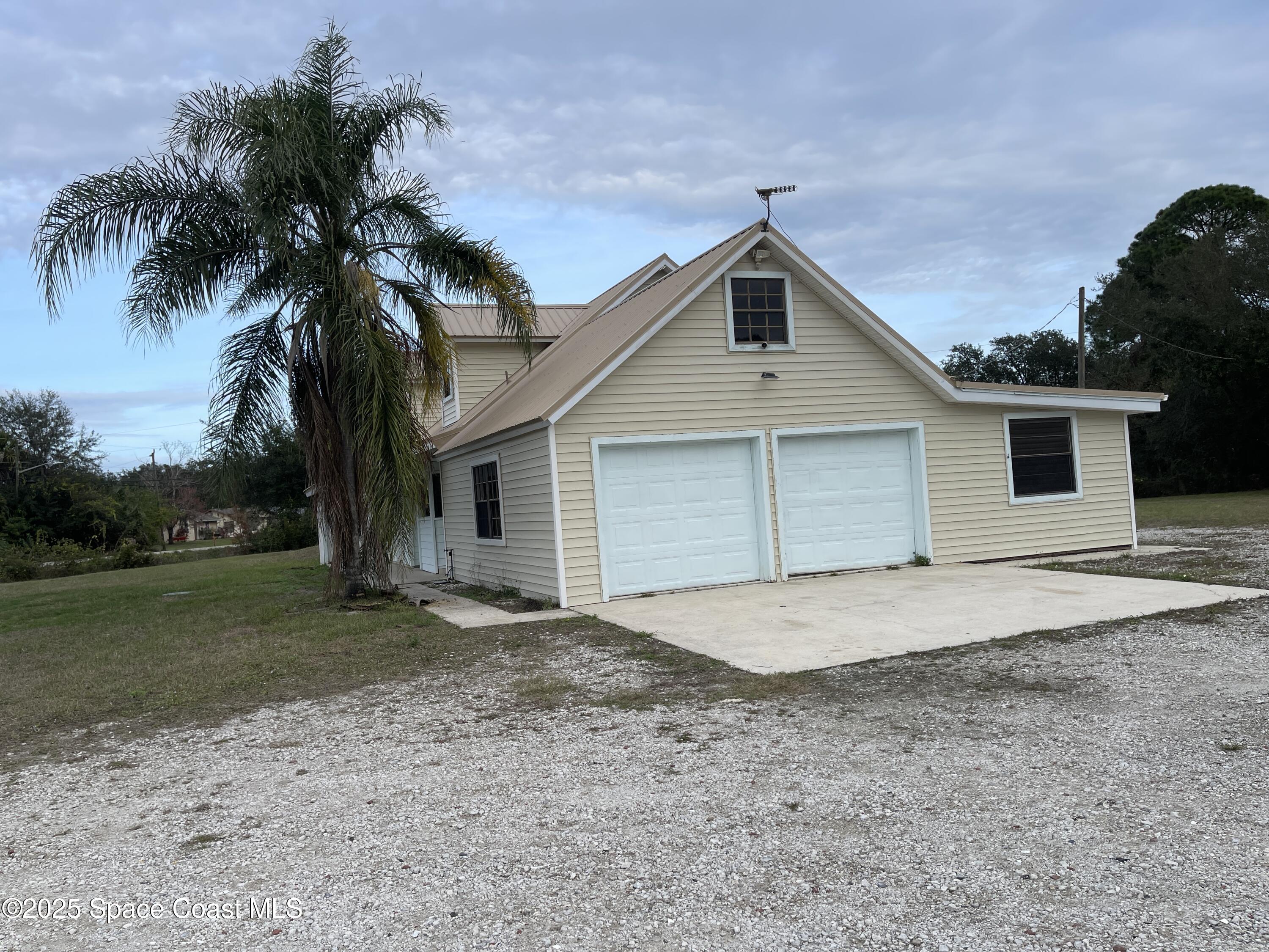 3445 Fox Lake Road Titusville, FL 32780 - Photo 2 of 43 a view of a house with a yard and palm trees