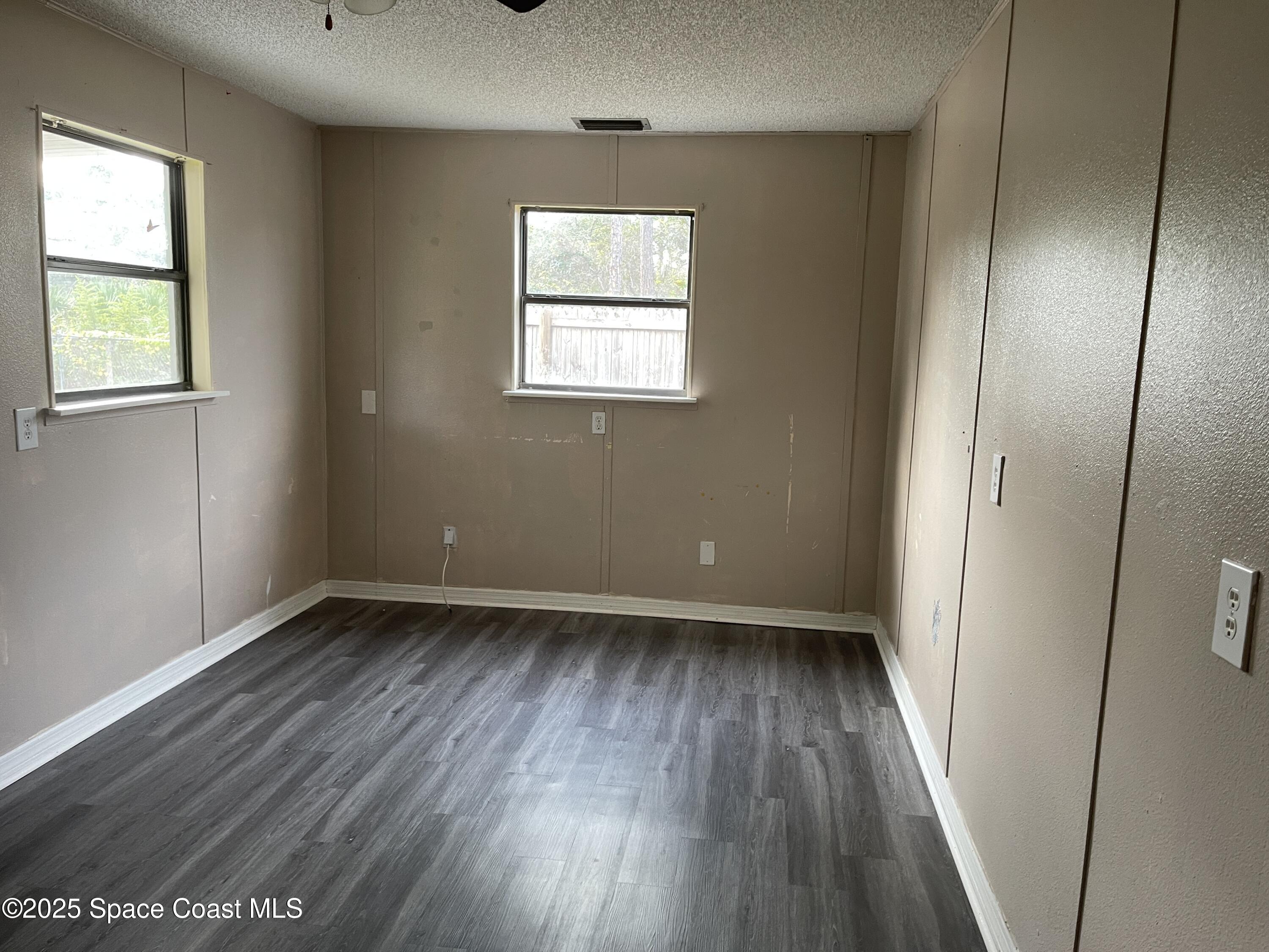 3445 Fox Lake Road Titusville, FL 32780 - Photo 28 of 43 an empty room with wooden floor and windows