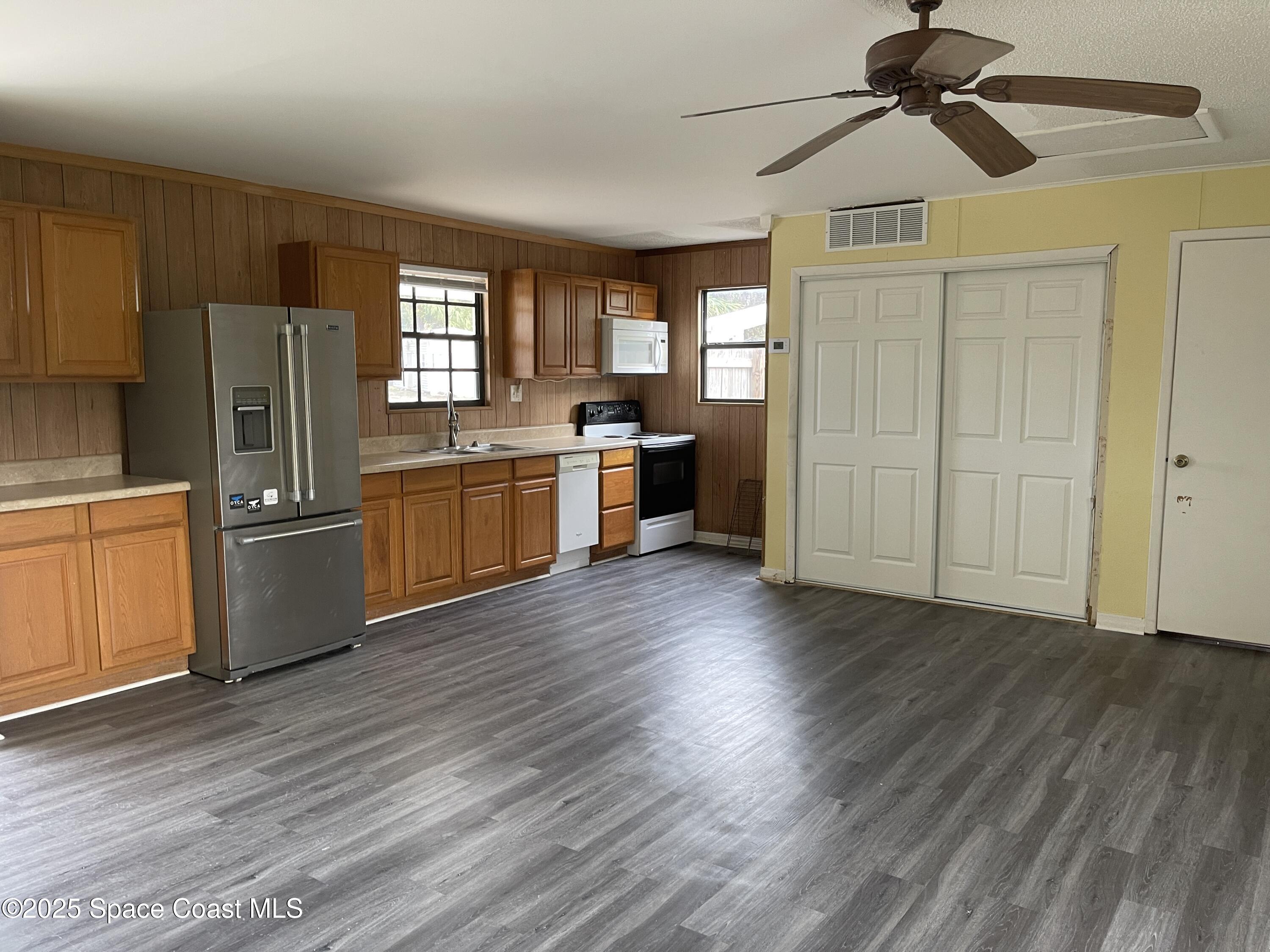 3445 Fox Lake Road Titusville, FL 32780 - Photo 36 of 43 a kitchen with stainless steel appliances granite countertop a refrigerator a sink dishwasher a stove and white countertops with wooden floor