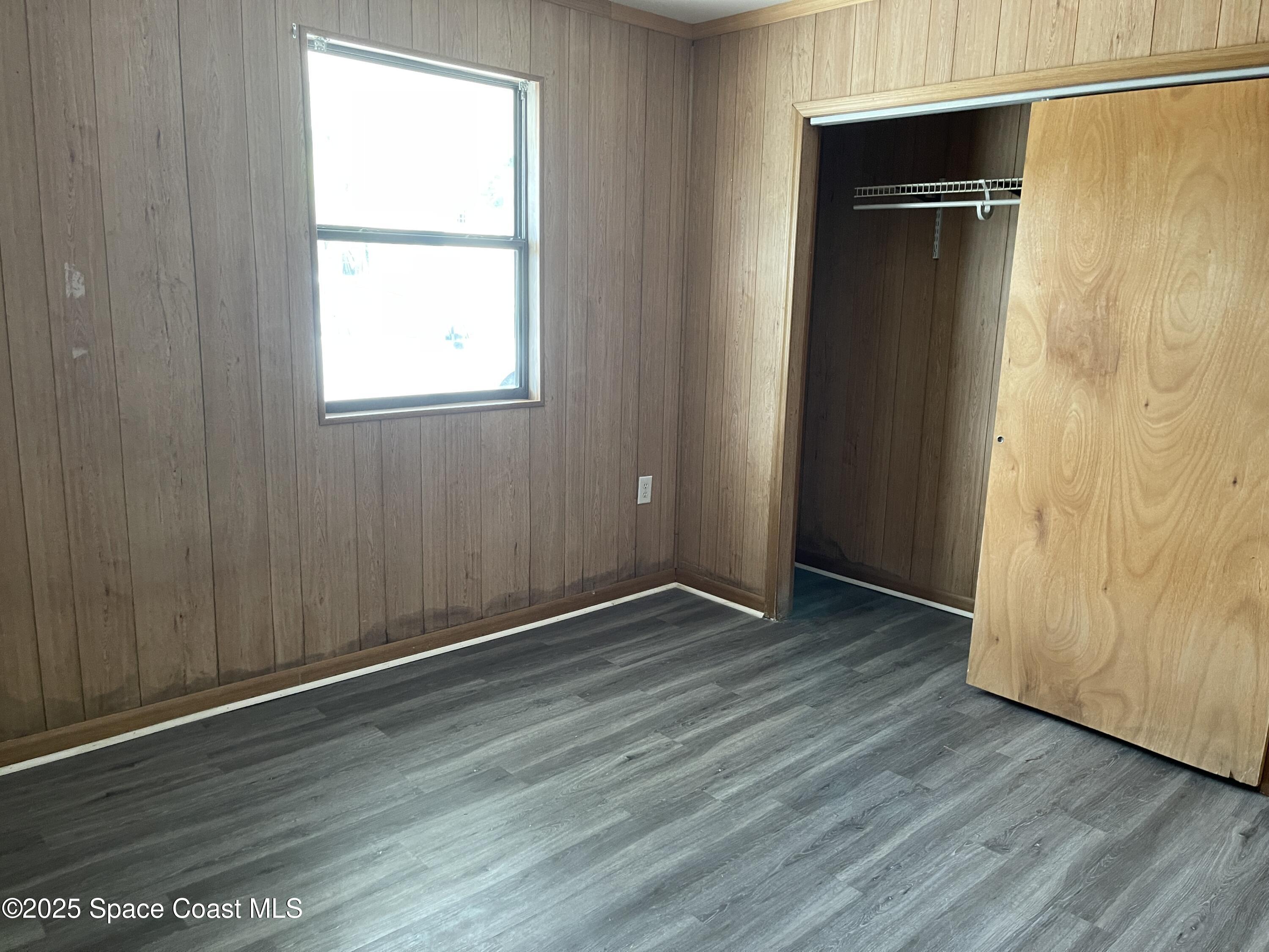 3445 Fox Lake Road Titusville, FL 32780 - Photo 39 of 43 an empty room with wooden floor and closet