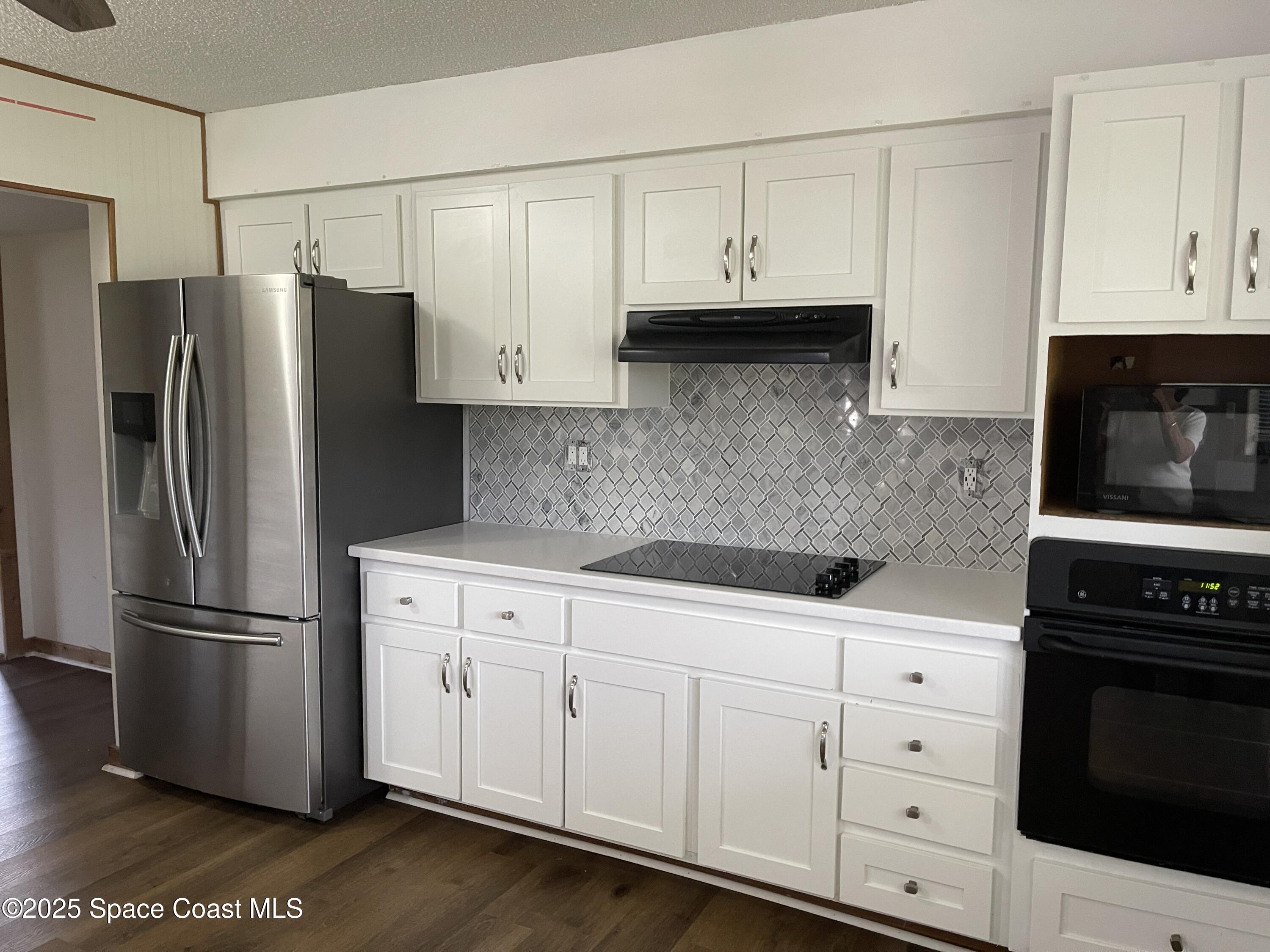 3445 Fox Lake Road Titusville, FL 32780 - Photo 10 of 43 a kitchen with white cabinets and stainless steel appliances