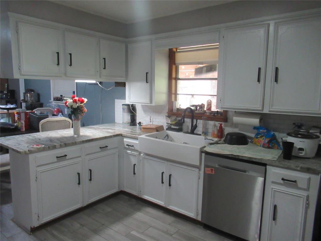 24133 Highway 157 Springhill, LA 71075 - Photo 11 of 19 Kitchen featuring white cabinetry, light-toned countertops, a farmhouse-style sink, a stainless steel dishwasher, and wood-finish flooring