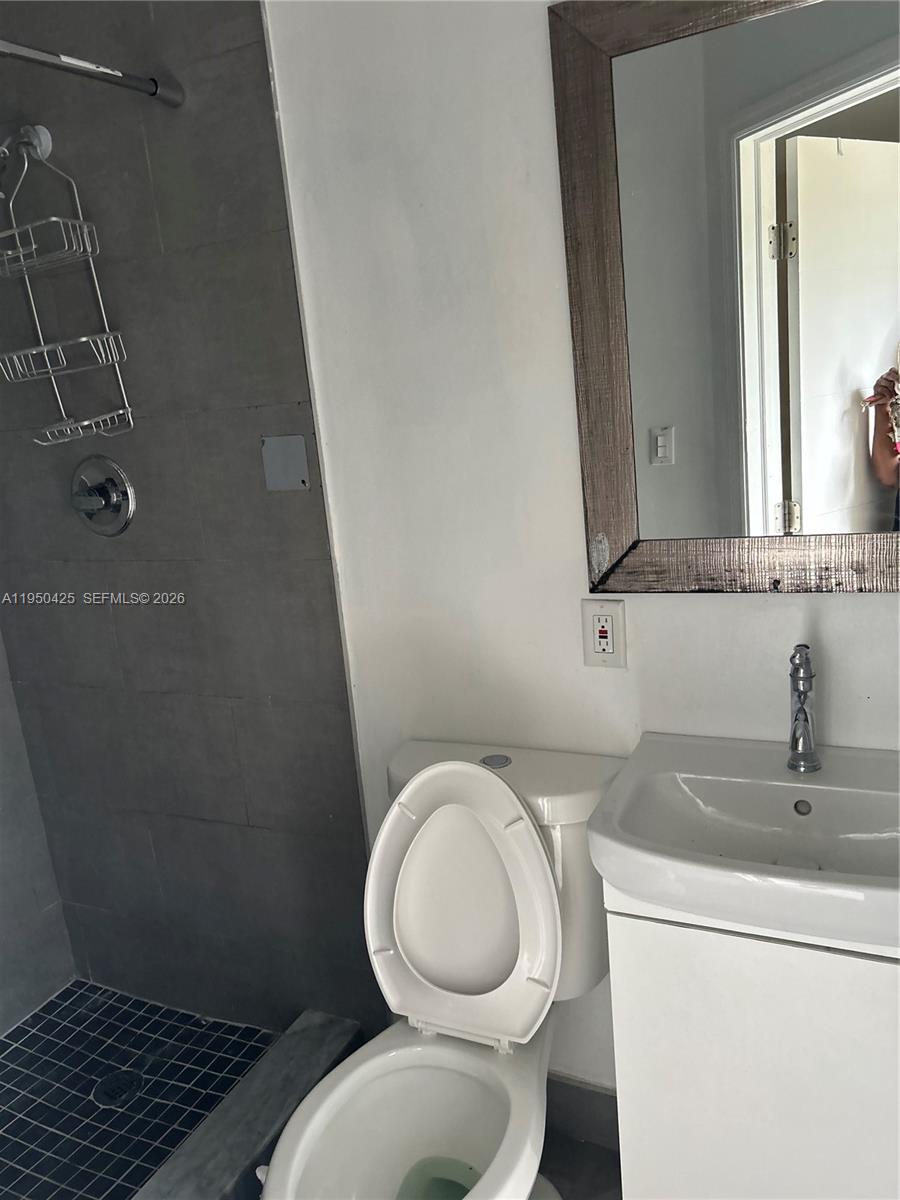 2300 Northwest 94th Street Miami, FL 33147 - Photo 3 of 6 a bathroom with a toilet a sink and mirror