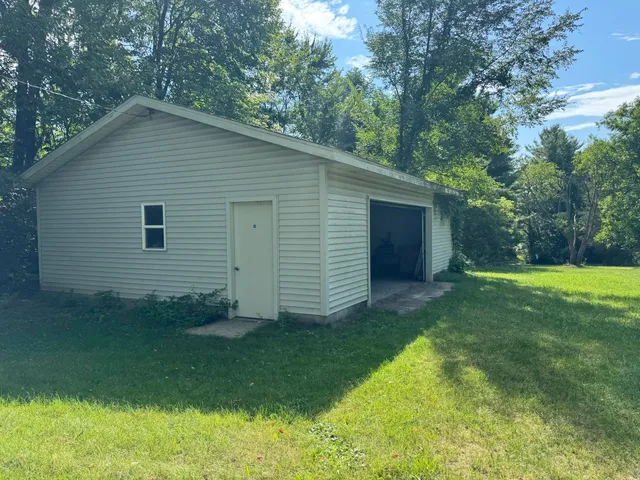 a view of a backyard with plants and large tree