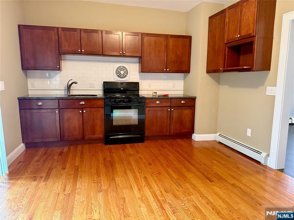 59 Laurel Avenue, Unit RIGHT SIDE Kearny, NJ 07032 - Photo 5 of 16 a kitchen with stainless steel appliances granite countertop a stove a sink dishwasher and a microwave with wooden floor