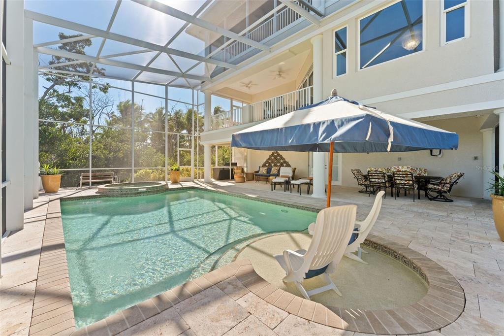 4150 Snail Island Court Boca Grande, FL 33921 - Photo 71 of 98 a view of a patio with a table and chairs under an umbrella
