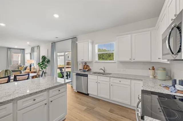a kitchen with white cabinets sink and stainless steel appliances