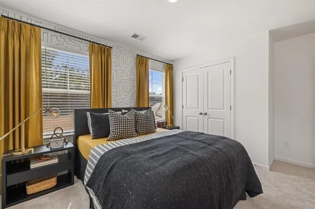 a bedroom with a bed and a large mirror on the dresser