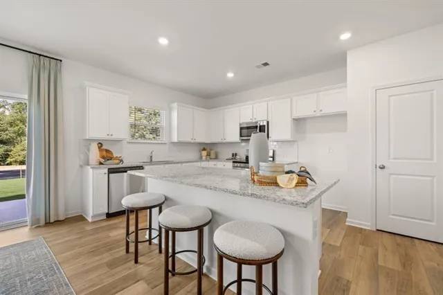 a kitchen with stainless steel appliances granite countertop a sink and a refrigerator