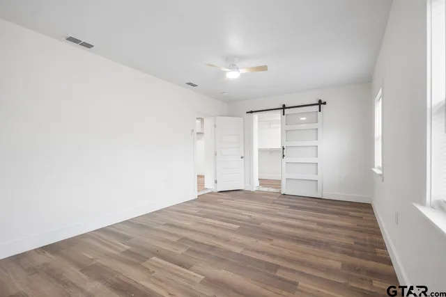 a view of empty room with wooden floor