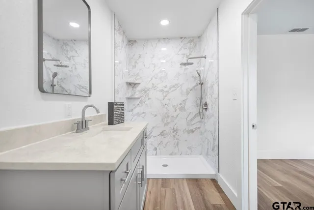 a bathroom with a sink a toilet and shower