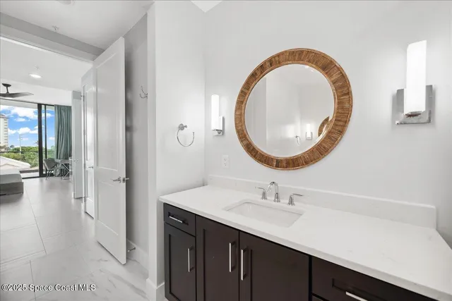 a bathroom with a granite countertop sink a mirror and shower