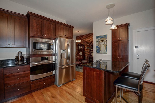 a kitchen with granite countertop wooden cabinets a refrigerator and a stove