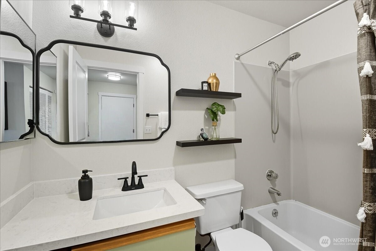 18150 73rd Avenue Northeast, Unit B306 Kenmore, WA 98028 - Photo 19 of 32 a bathroom with a sink a toilet and a mirror