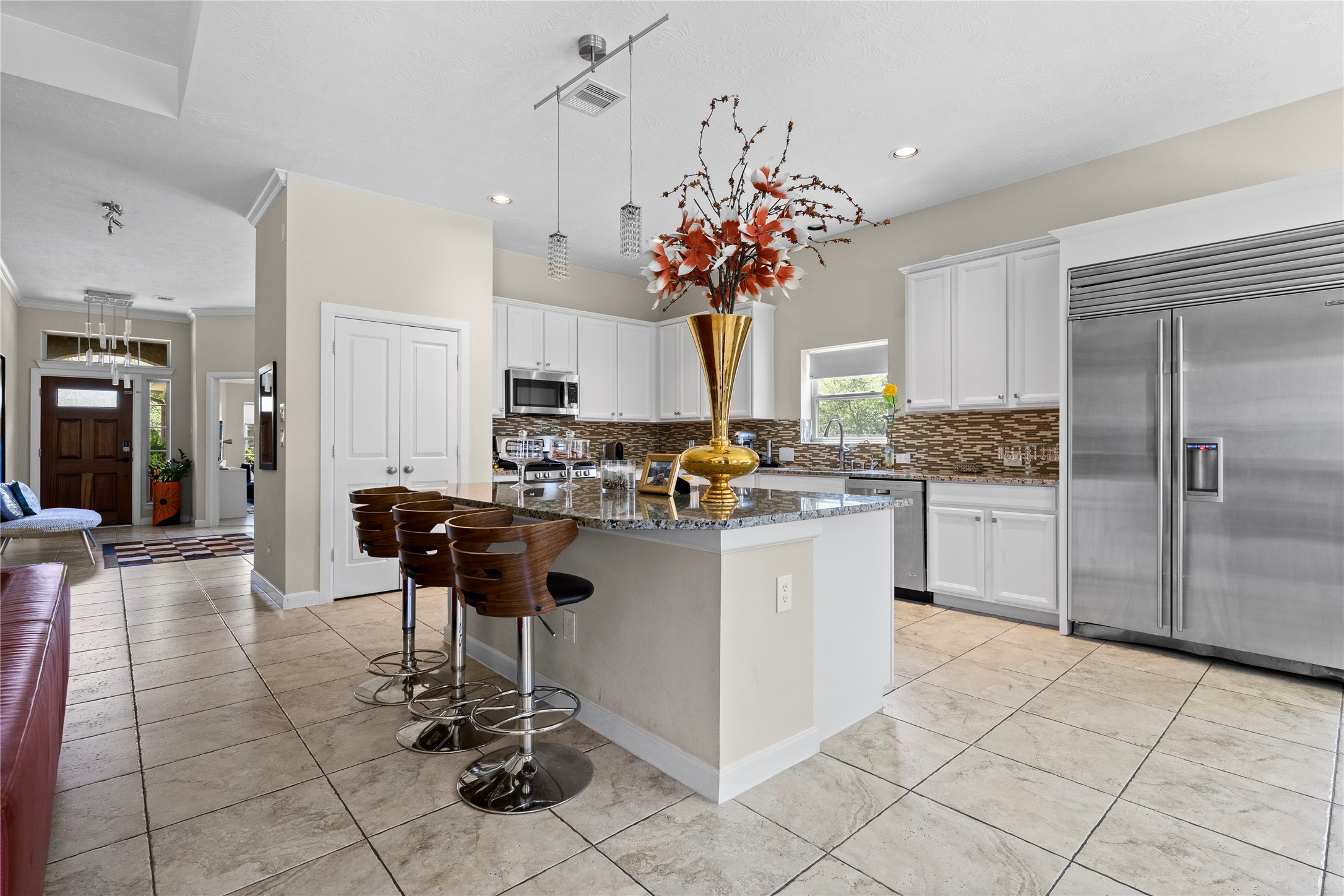 31503 Reston Cliff Court Spring, TX 77386 - Photo 2 of 28 a kitchen with stainless steel appliances kitchen island granite countertop a table chairs and a refrigerator