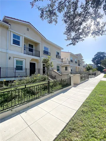 a view of a house with a small yard and wooden fence