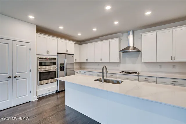 a kitchen with kitchen island granite countertop a sink stainless steel appliances and cabinets