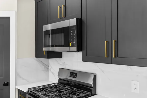 a kitchen with stainless steel appliances a stove a microwave and sink