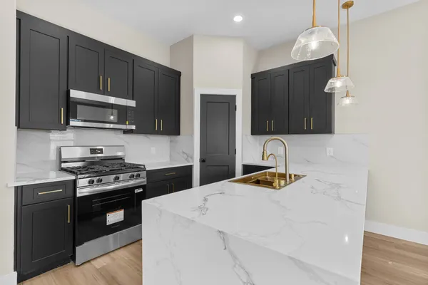 a kitchen with stainless steel appliances granite countertop a refrigerator and a stove