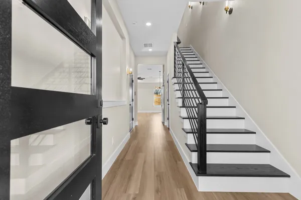 a view of staircase with wooden floor and white walls