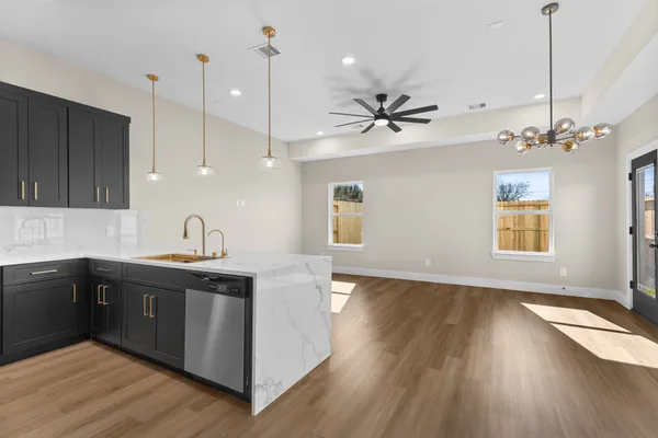 a kitchen with stainless steel appliances granite countertop a sink a stove a refrigerator and wooden floor