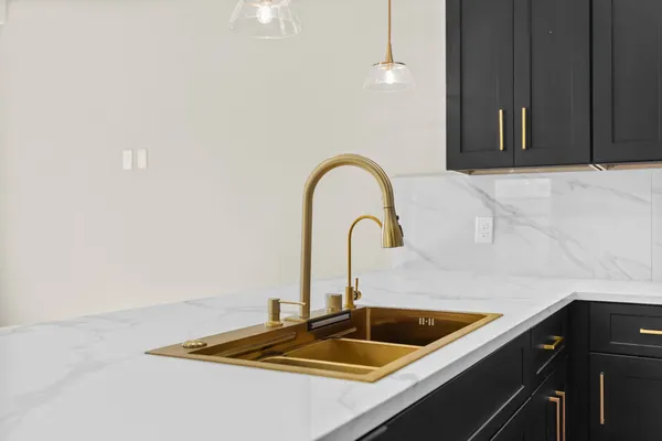 a kitchen with white cabinets and stove