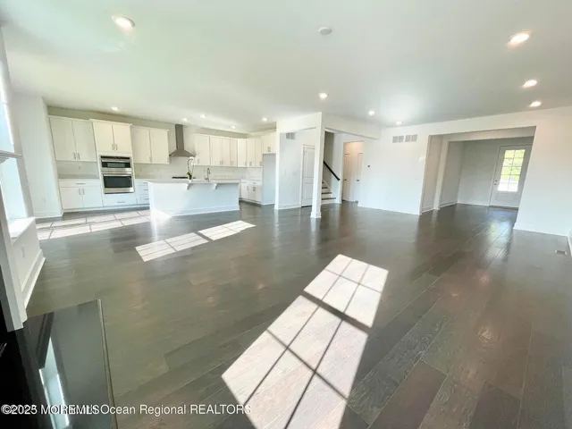 a view of a living room with hardwood floor and a kitchen