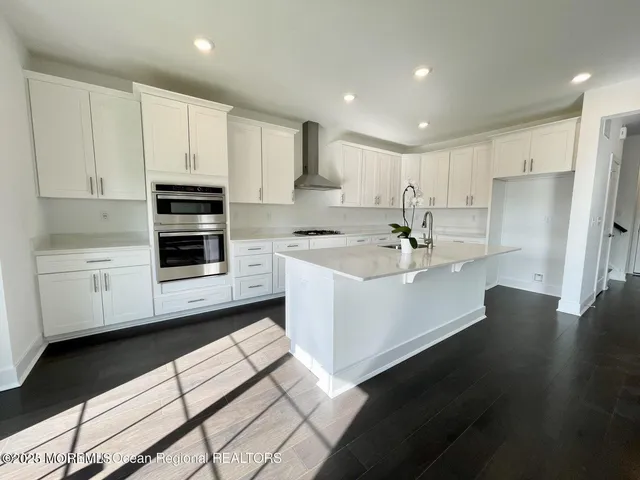 a kitchen with a sink stainless steel appliances and white cabinets