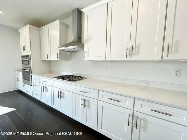 a kitchen with stainless steel appliances granite countertop white cabinets and a sink