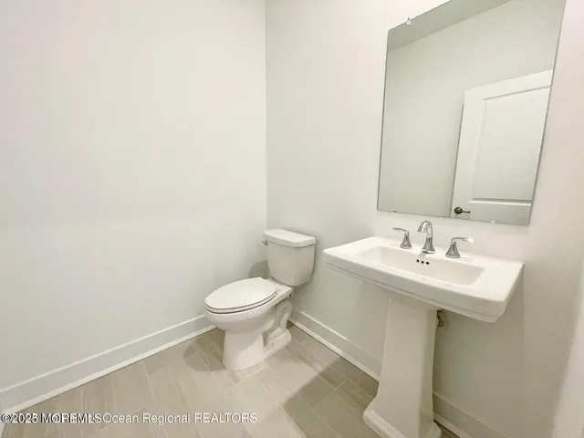 a bathroom with a toilet a sink and a mirror